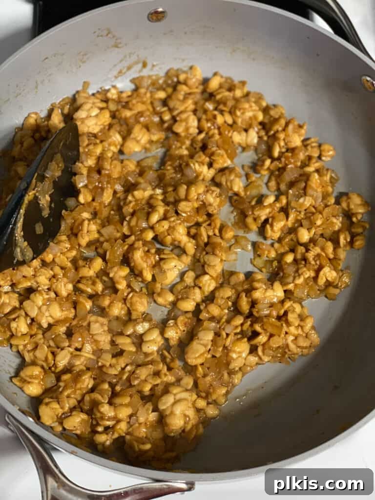 Crispy Tempeh with Zesty Ginger-Soy Glaze 11 Process shot of mixing all ingredients together in the pan until coated and glazed.
