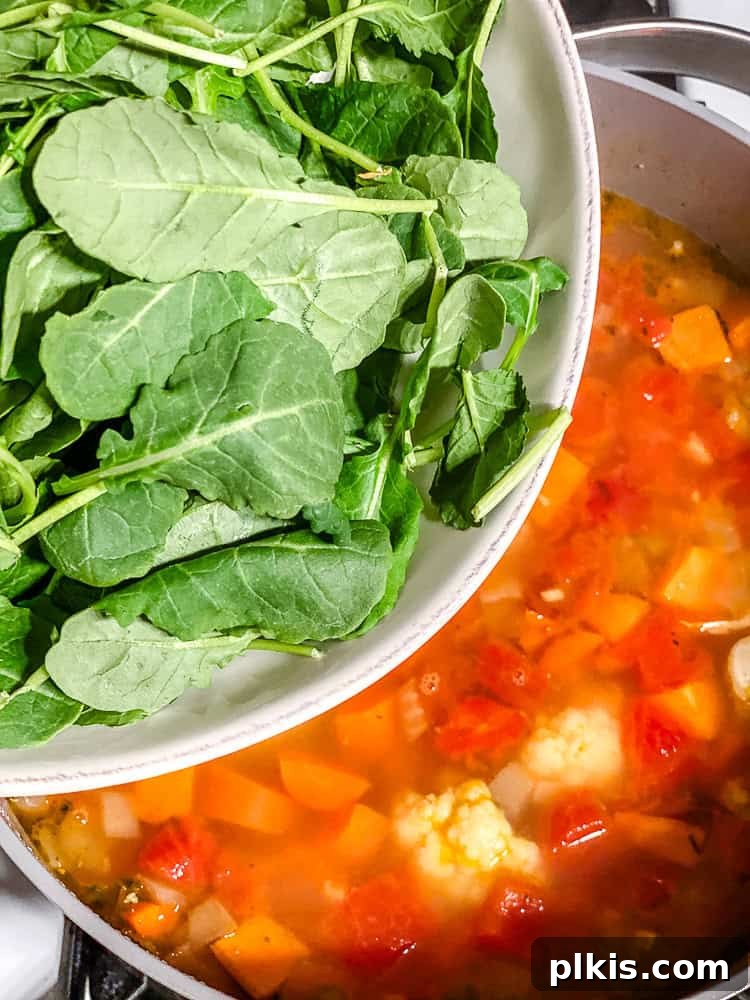 Nourishing Kale and Bean Harvest Soup 6 process shot of adding kale to pot