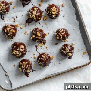 Loaded Chocolate Peanut Butter Truffles 9 Completed Chocolate Covered Peanut Butter Balls (+ Add-Ins) on a baking sheet.