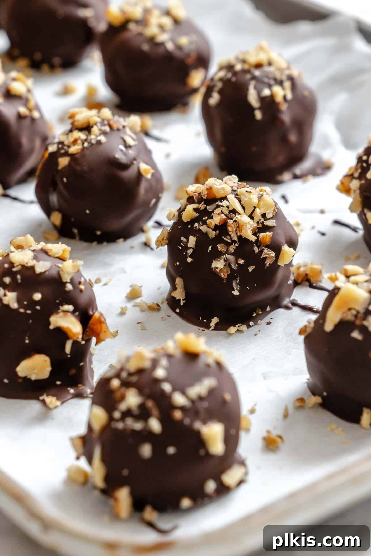 Loaded Chocolate Peanut Butter Truffles 7 Completed Chocolate Covered Peanut Butter Balls (+ Add-Ins) on a baking sheet.