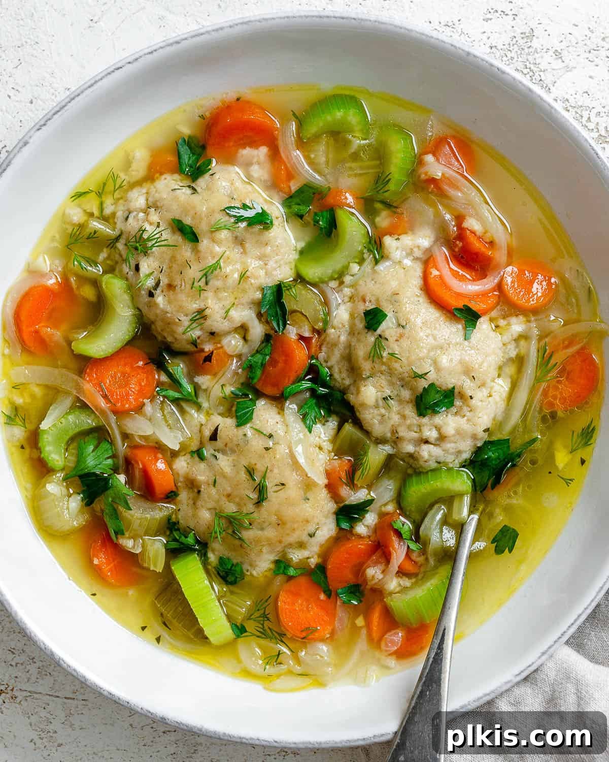 Comforting Vegan Matzo Ball Soup 2 completed Vegan Matzo Ball Soup in a bowl, garnished with fresh herbs