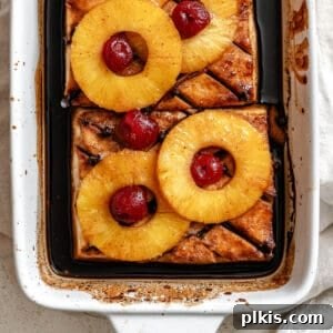 A beautifully completed Pineapple Glazed Tofu Ham in a baking dish, perfectly browned and topped with festive pineapple and cherries, ready to be served. This amazing vegan centerpiece is sweet, savory, and looks pretty on any holiday table.
