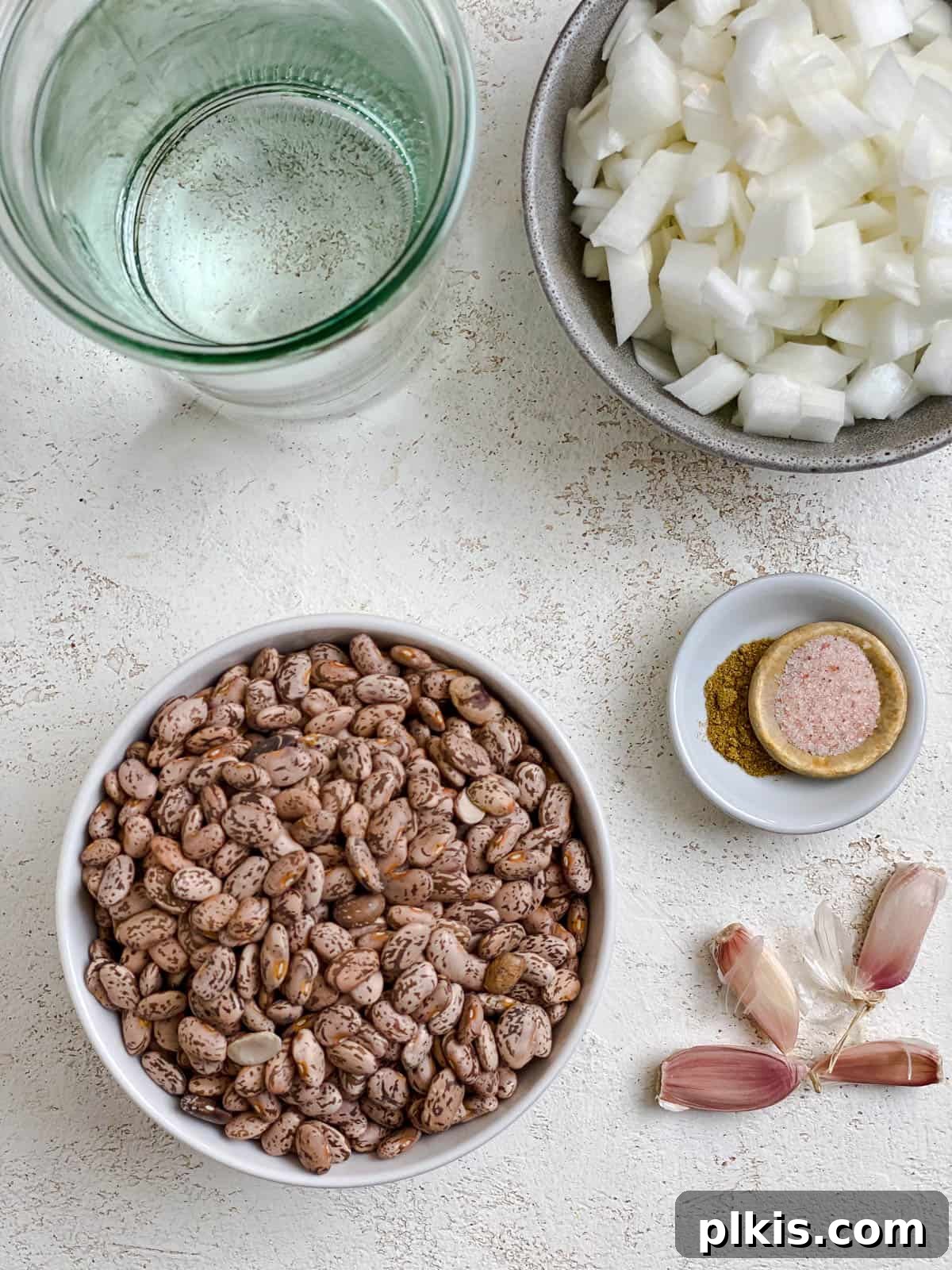 Perfectly Cooked Instant Pot Pinto Beans 3 ingredients for Instant Pot Pinto Beans measured out against a white surface