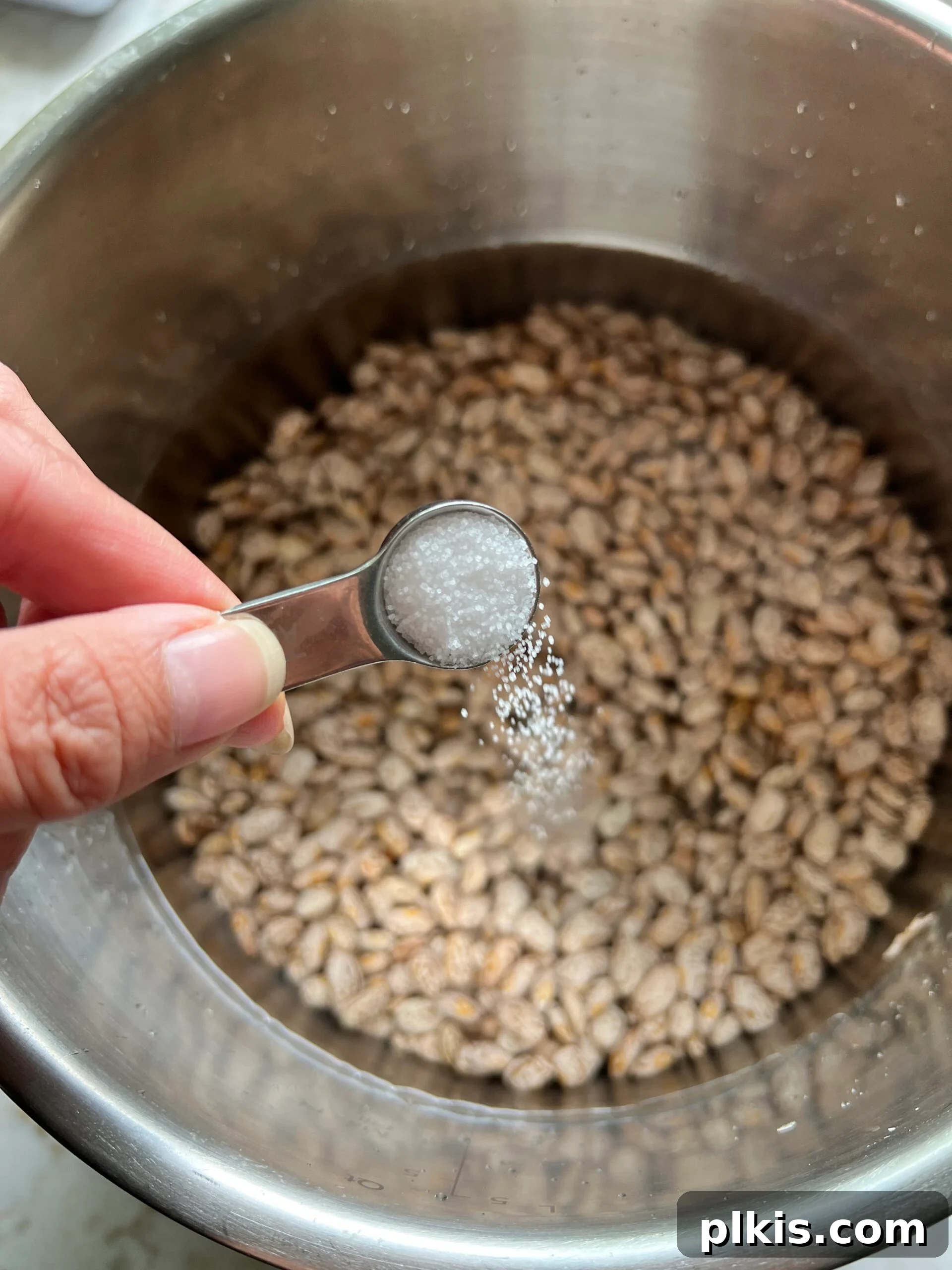 Perfectly Cooked Instant Pot Pinto Beans 6 process of adding salt to pinto bean and water mixture