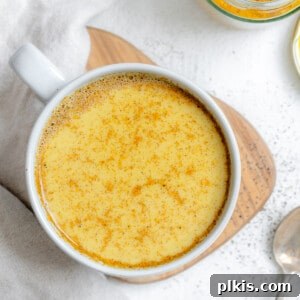 completed Turmeric Golden Milk [Haldi Doodh] in a white cup against a white background