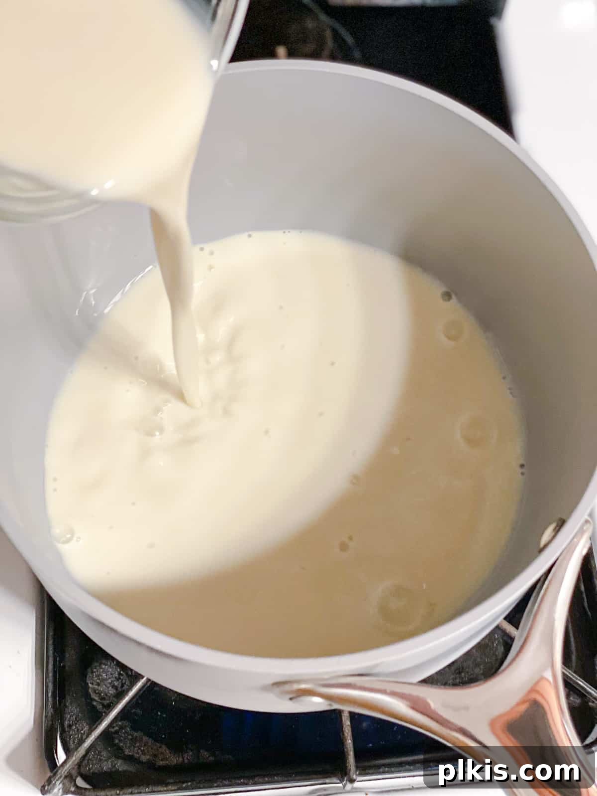 Golden Turmeric Elixir 4 Process shot showing plant-based milk being poured into a saucepan as the first step for making golden milk.