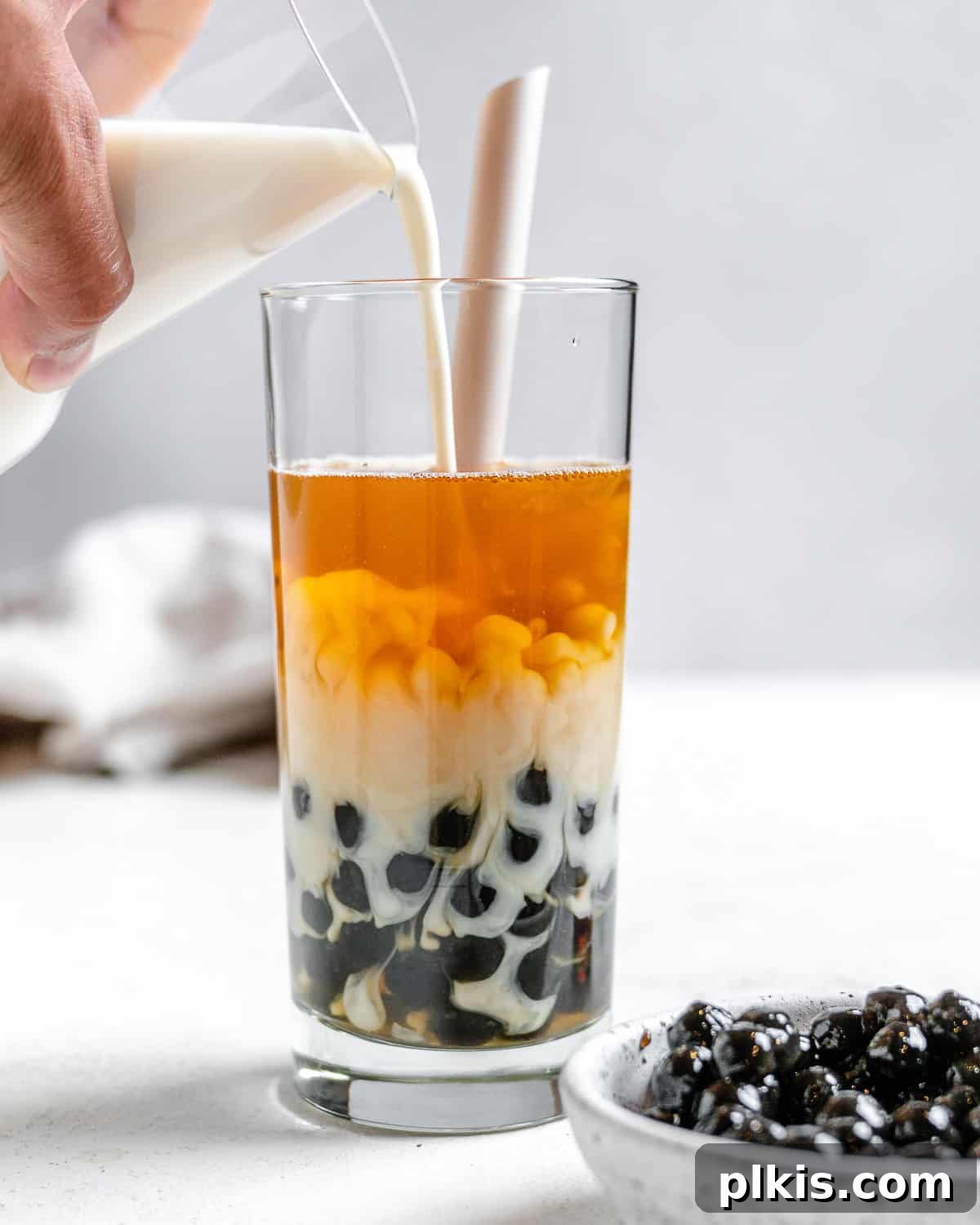Simple Vegan Boba Bliss 7 The final step in making Easy Vegan Bubble Tea, showing the addition of the last touch of creamer to complete the drink.