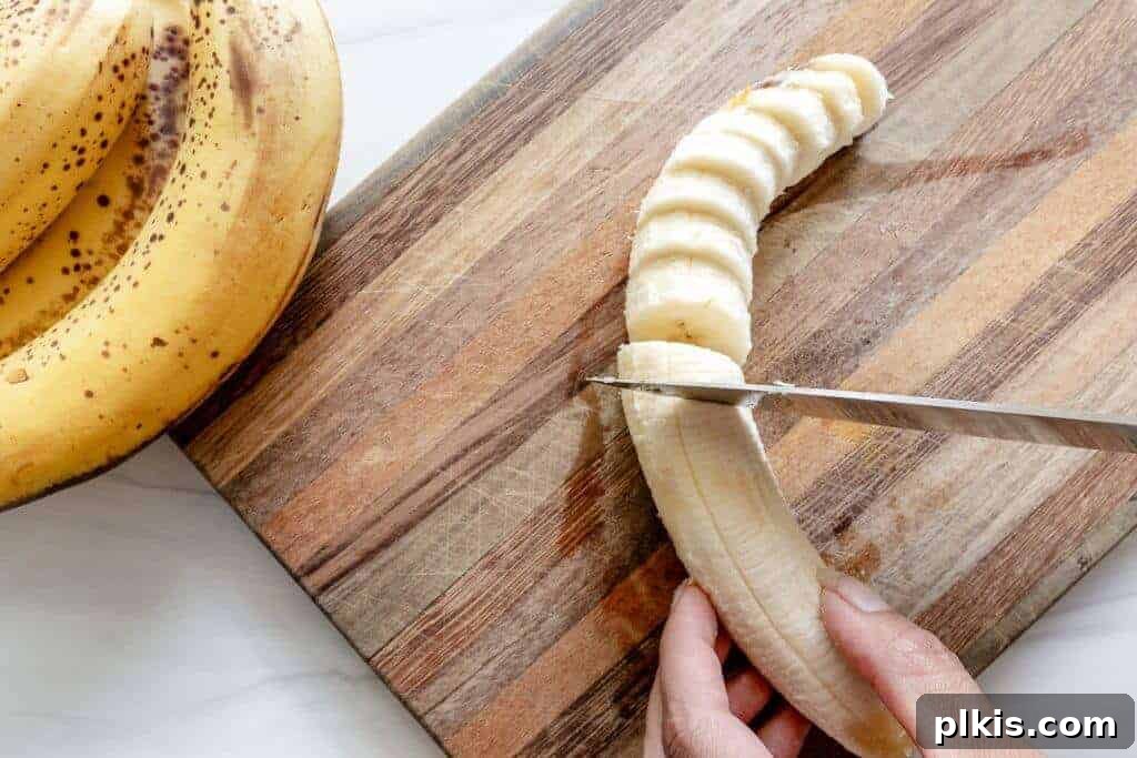 Extend Banana Life: Freezing Made Simple 4 A banana being sliced on a wood board.