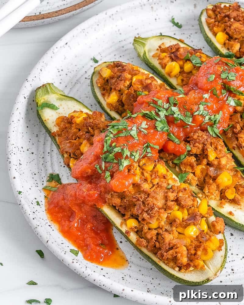 A close-up view of a beautifully baked Vegan Zucchini Boat, revealing the golden-brown filling and tender zucchini.