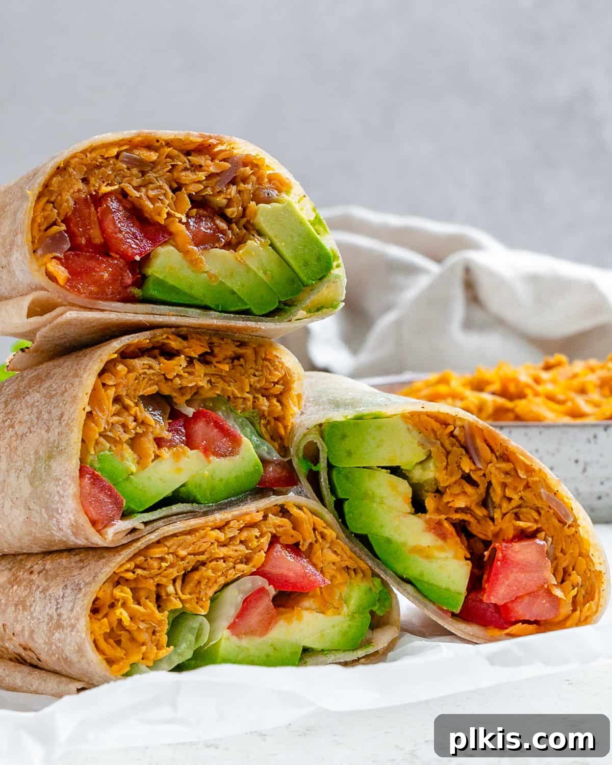 Roasted Sweet Potato and Black Bean Burritos 2 completed Sweet Potato Burritos stacked on one another against a light background