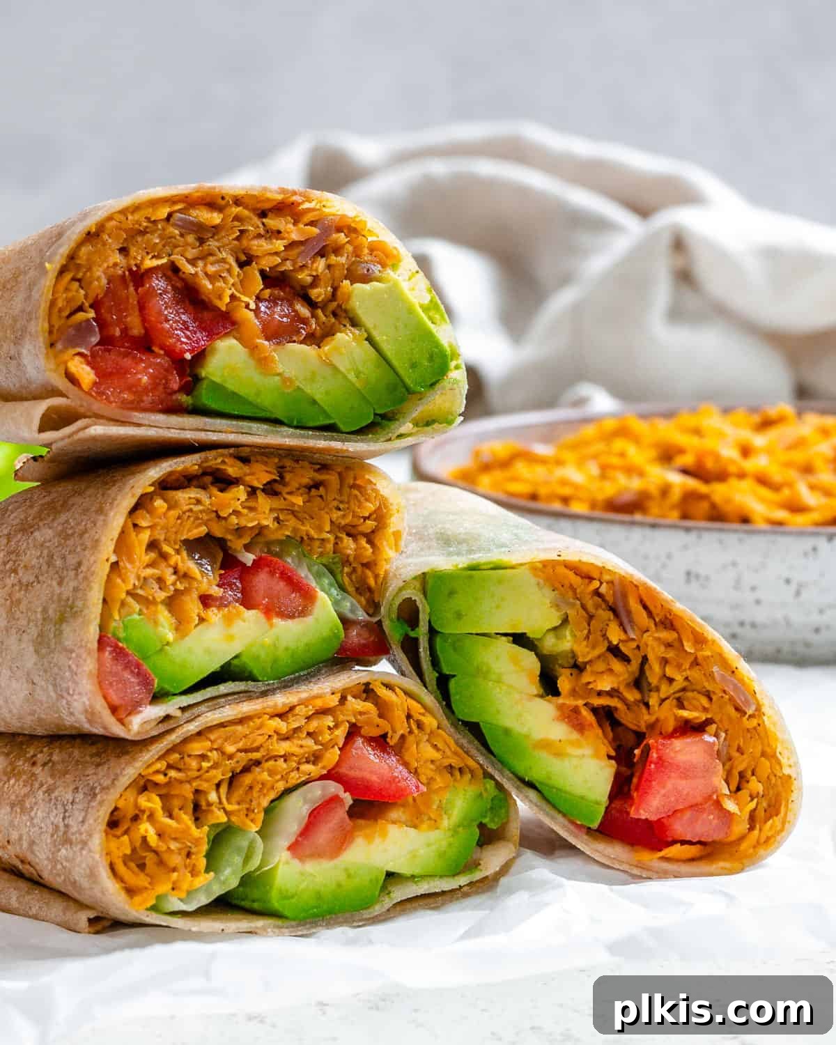 Roasted Sweet Potato and Black Bean Burritos 12 completed Sweet Potato Burritos stacked on one another against a light background