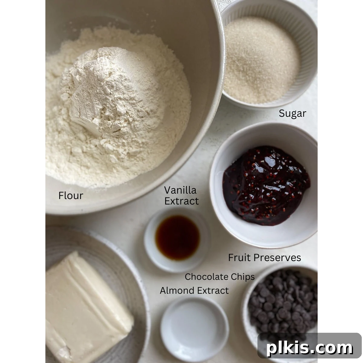 Ruby Raspberry Thumbprint Delights 3 ingredients for Raspberry Thumbprint Cookies measured out against a white surface