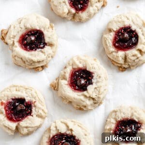 Ruby Raspberry Thumbprint Delights 20 completed Raspberry Jam Thumbprint Cookies scattered on a white surface