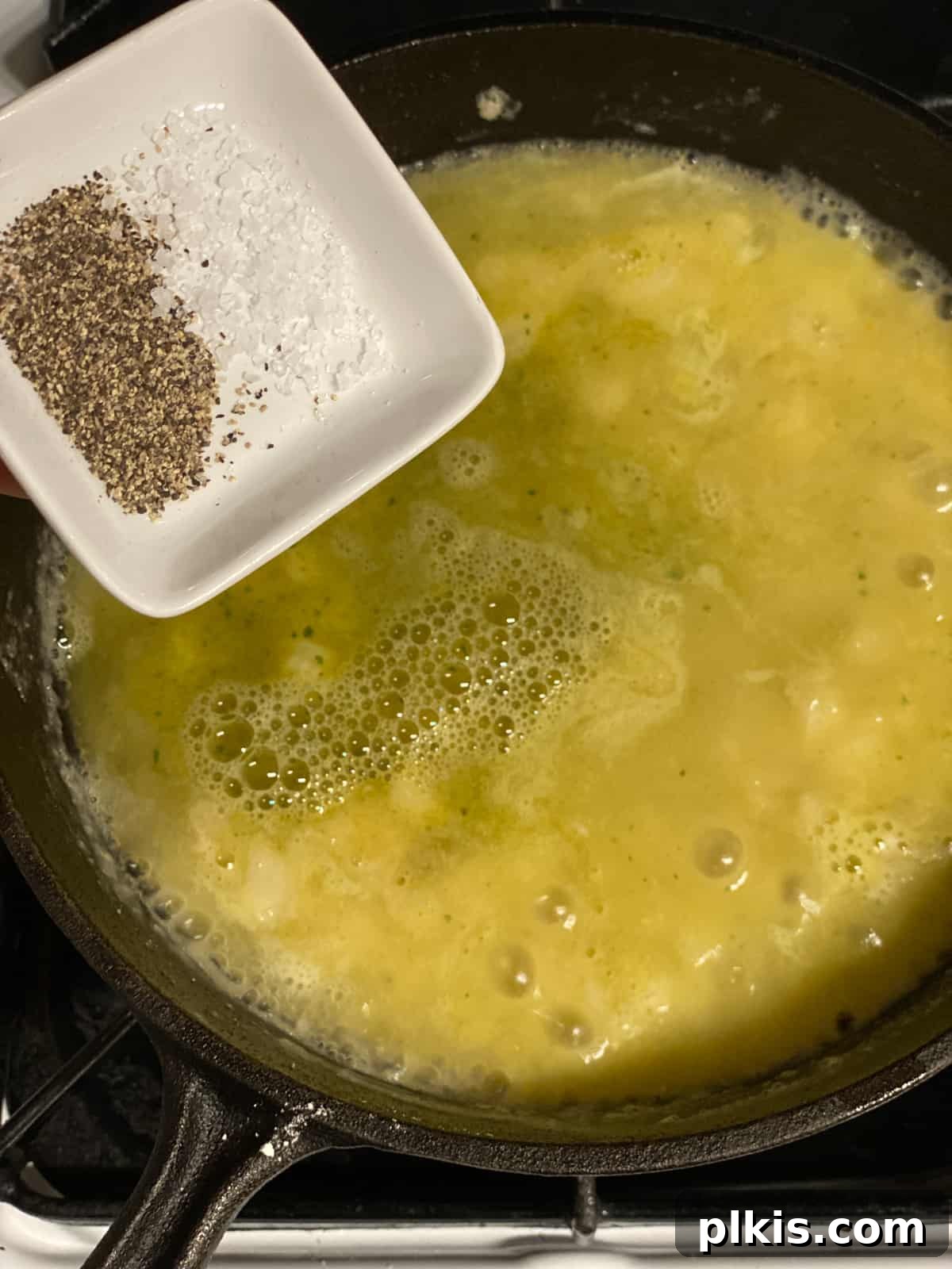 Effortless Plant-Based Gravy 6 Seasoning the thickening vegan gravy with salt and pepper in a pan, ensuring a perfectly balanced flavor.