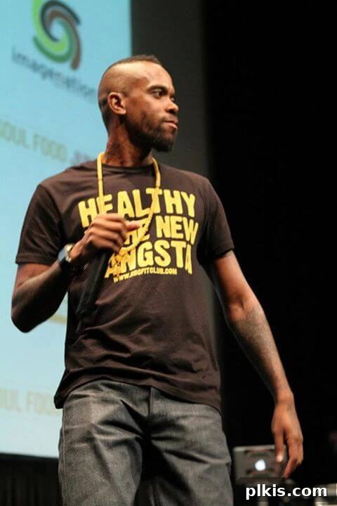 Urban Fuel Eating Right On A Dime 2 Stic wearing a "Healthy is the New Gangsta" t-shirt, promoting a lifestyle of wellness and strength and inspiring others to prioritize their well-being.