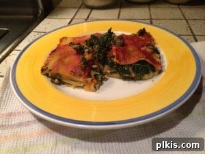 Budget Plant-Based Challenge for Two Week 2 13 A serving of Potato Lasagna on a white plate, showing layers of noodles, mashed potatoes, and marinara sauce.