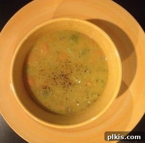Budget Plant-Based Challenge for Two Week 2 5 A rustic bowl of thick, green split pea soup garnished with fresh herbs, ready to be served.