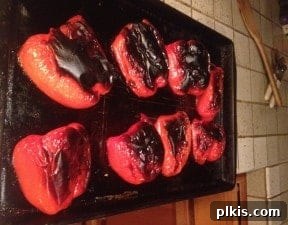 Budget Plant-Based Challenge for Two Week 2 10 Broiled red bell peppers with blackened and blistered skins, cooling in a brown paper bag to facilitate peeling.