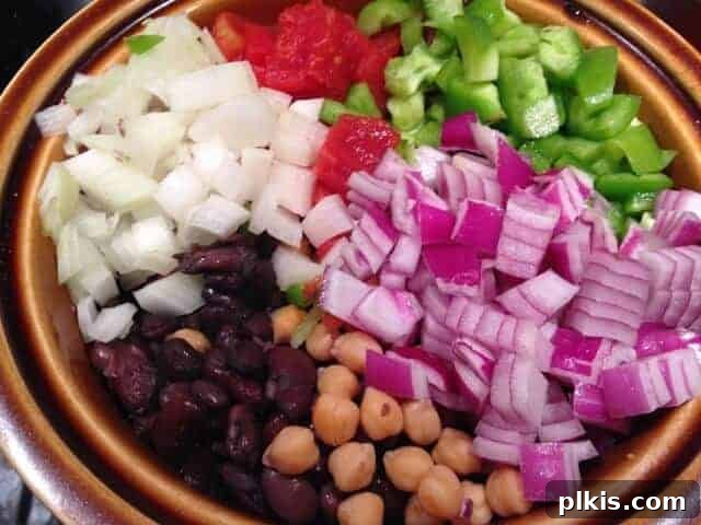 Frugal Vegan Feasts for One: Week 2 Progress 6 Chopped red onion, white onion, green peppers, and cooked beans in a brown bowl.