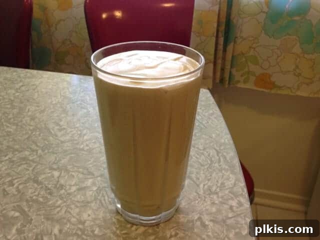 Solo Budget Plant Based Challenge Week 3 15 A glass of peanut butter banana smoothie on a table.