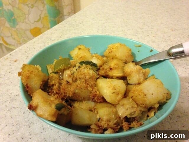 Solo Budget Plant Based Challenge Week 3 4 Small bowl of zucchini potato casserole topped with bread crumbs.