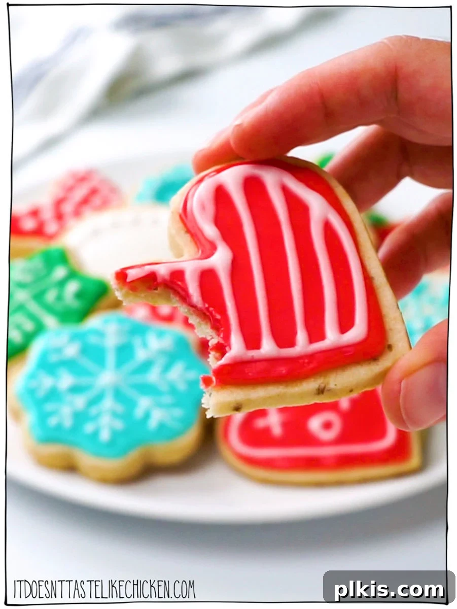 24 Festive Vegan Christmas Cookie Delights 11 Completed Vegan Sugar Cookies on a plate with a close up of one cookie.