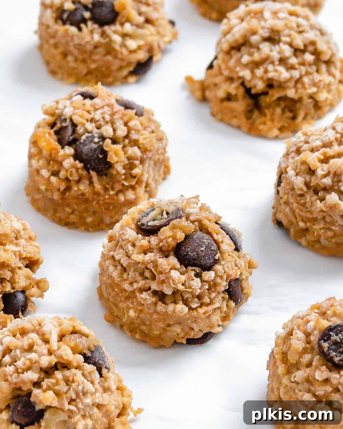 24 Festive Vegan Christmas Cookie Delights 21 Completed Vegan Chocolate Chip Quinoa Cookies spread out on a white surface.