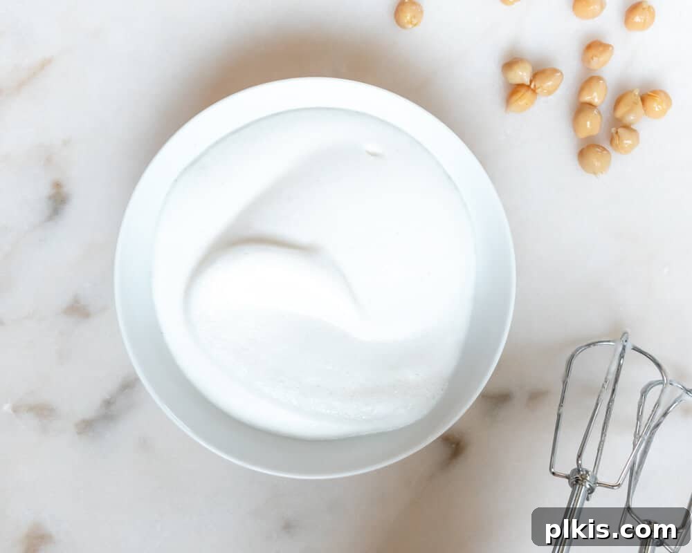 Best Vegan Egg Replacers for Baking A Bowl of Fluffly Chickpea Brine or Aquafaba with some chickpeas on the side