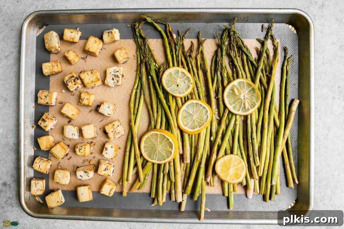 Sheet Pan Lemon Pepper & Herb Tofu with Asparagus and Tahini Dressing Sheet Pan with some cubed tofu, asparagus and lemon