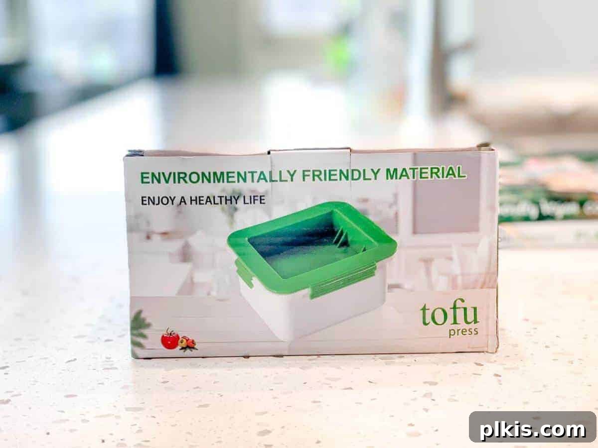 Guide to Tofu Pressing: XKiss Tofu Press Review XKiss Tofu Press in its box on a marble counter, emphasizing its clean and efficient design for moisture removal.