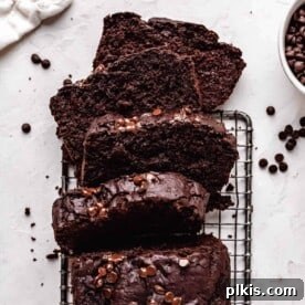 A decadent slice of vegan chocolate zucchini bread, showcasing its moist texture and rich chocolate flavor.