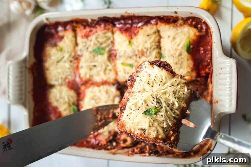 Zucchini Lasagna A pre-cut vegan zucchini lasagna, beautifully presented in a light-colored baking tray.
