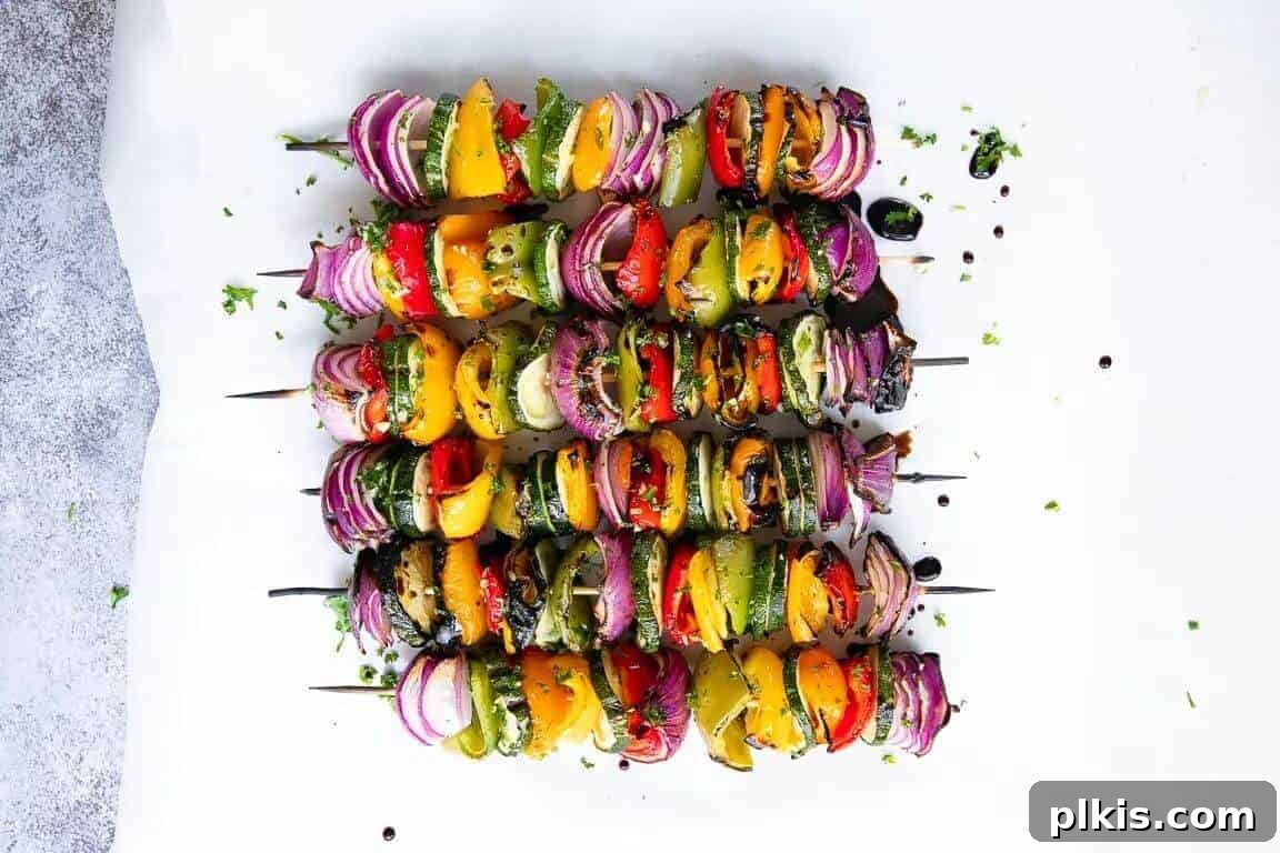 Grilled Veggie Kebabs Six vibrant veggie kebabs, loaded with a colorful mix of vegetables on skewers, presented against a clean white background.