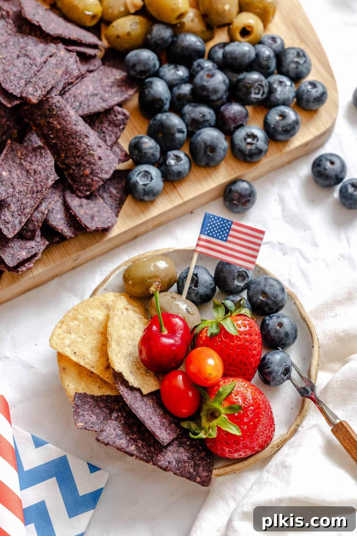 Red, White & Blue Charcuterie Board 4 A beautifully arranged 4th of July Charcuterie Board, ready to serve, with a small plate beside it for guests.