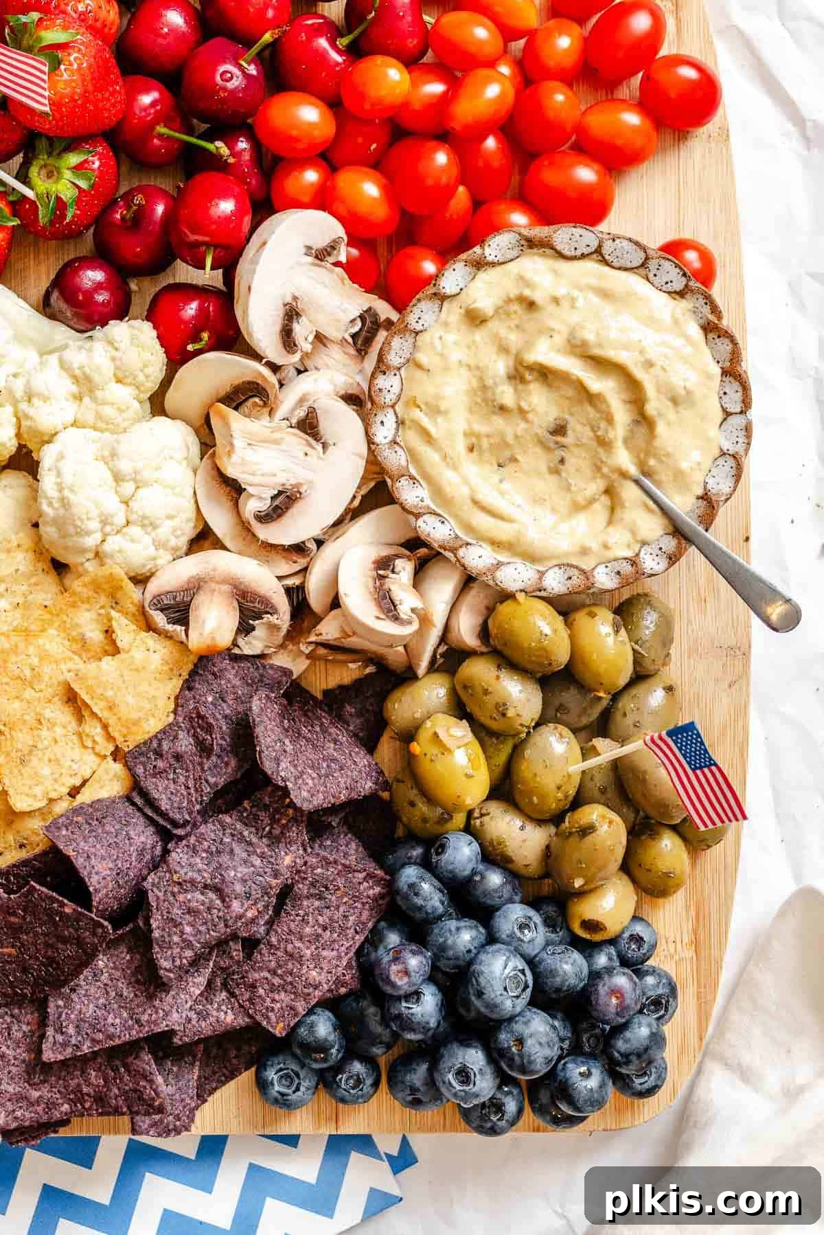 Red, White & Blue Charcuterie Board 5 The fully assembled 4th of July Charcuterie Board, glistening with fresh red, white, and blue ingredients, ready to be enjoyed.