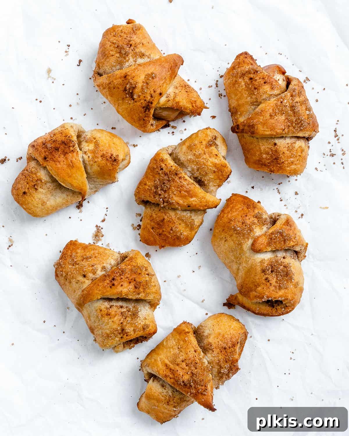 48 Irresistible Vegan Apple Delights 10 Completed vegan apple crescents scattered on a white surface.