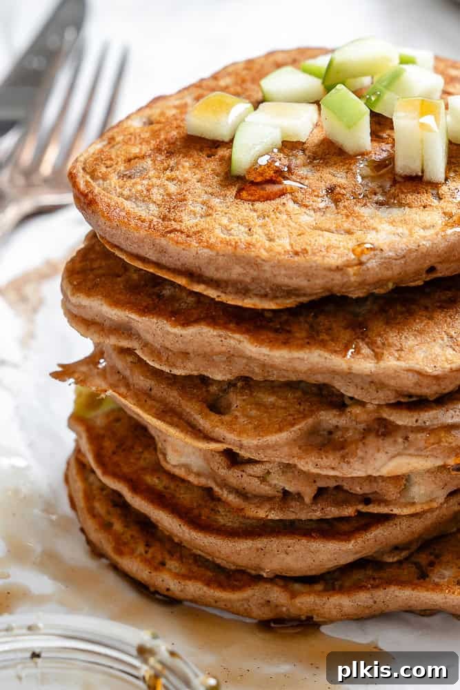 48 Irresistible Vegan Apple Delights 3 Completed stack of Apple Cinnamon Pancakes on a white surface.