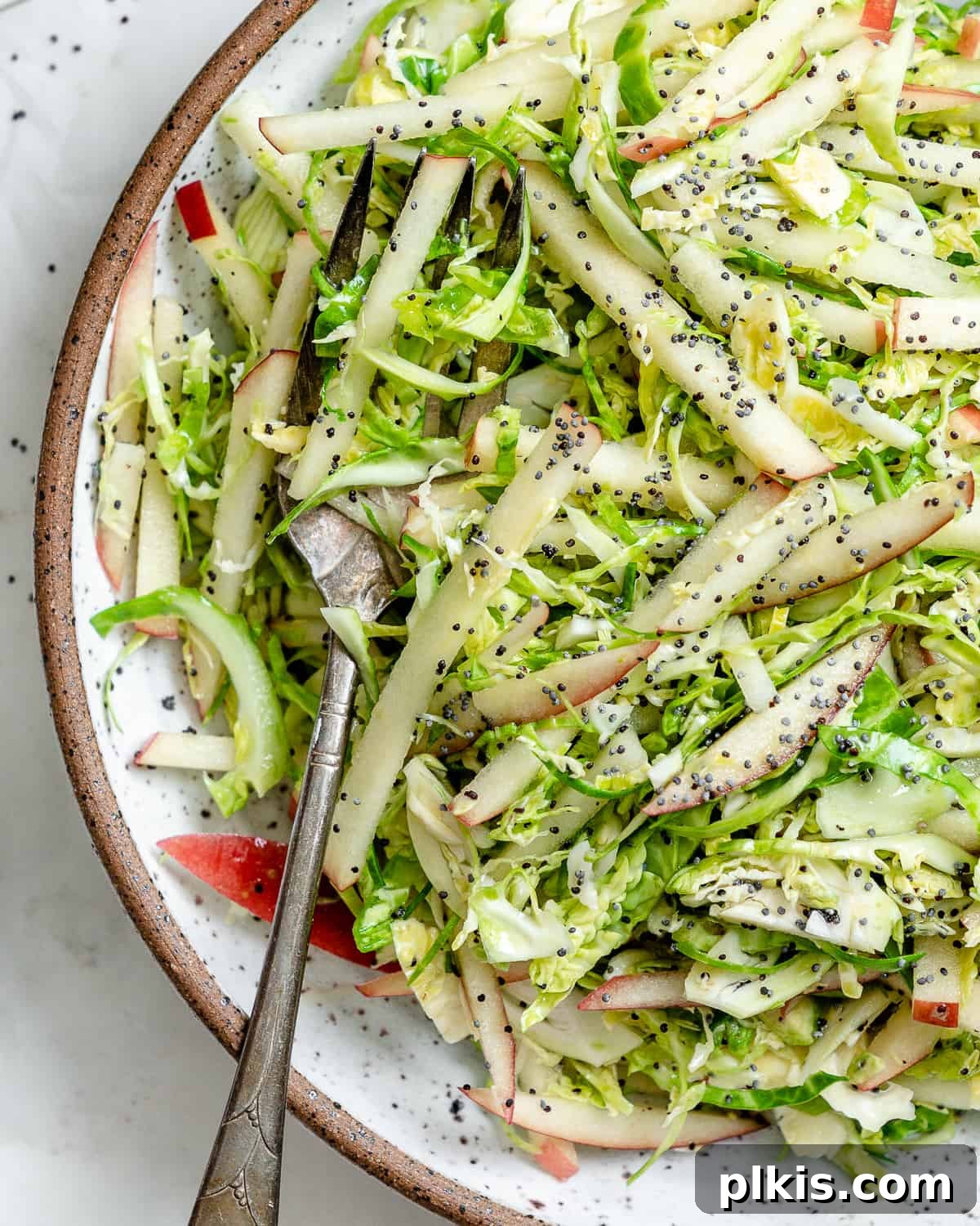 48 Irresistible Vegan Apple Delights 26 Completed Shaved Brussel Sprout Slaw with Apples in a bowl.