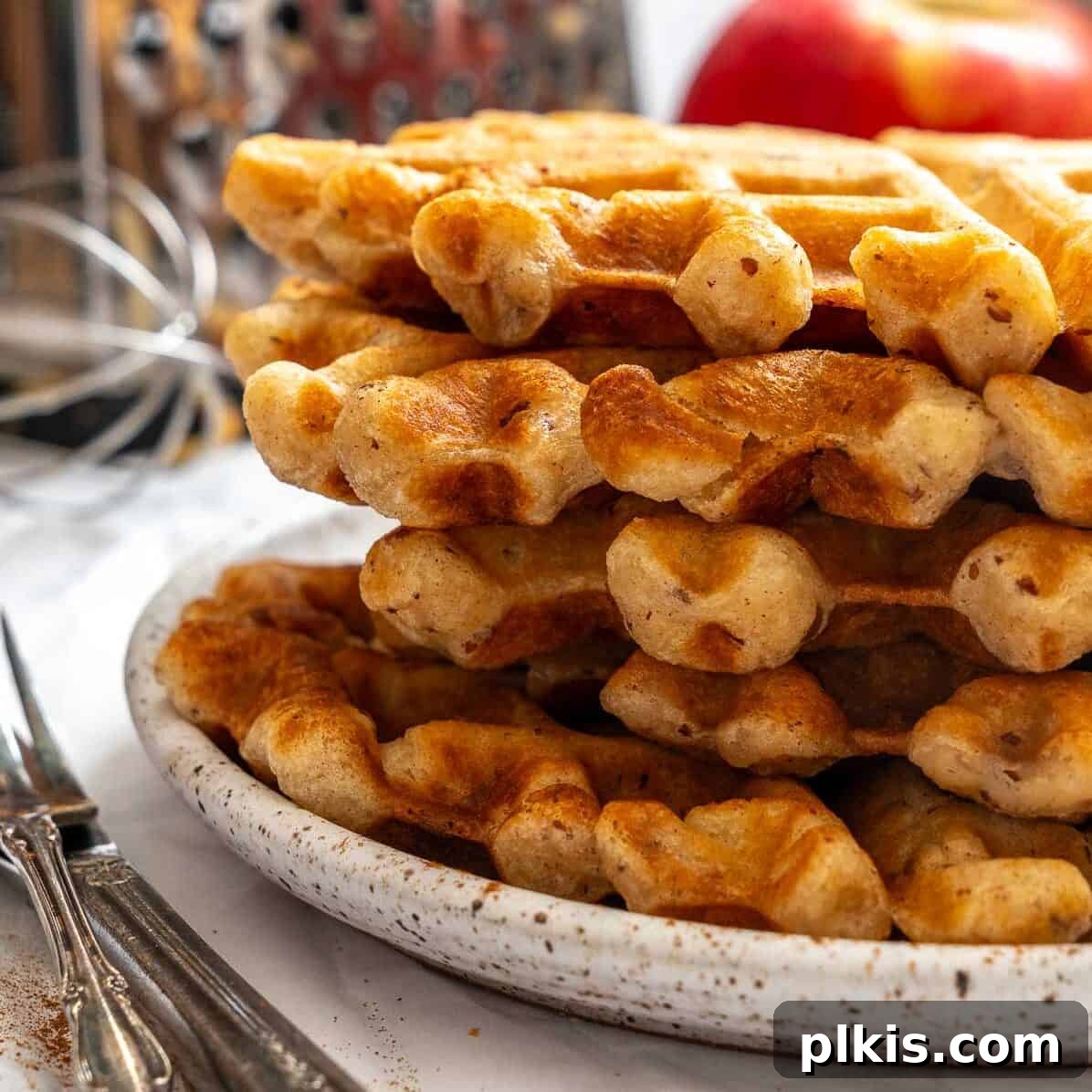 48 Irresistible Vegan Apple Delights 5 Completed Apple Cinnamon Waffles (Eggless) stacked on a plate.