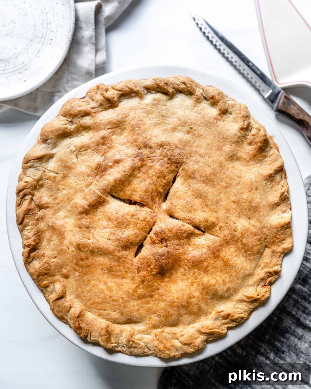 48 Irresistible Vegan Apple Delights 32 Completed Vegan Apple Pie on a white surface.