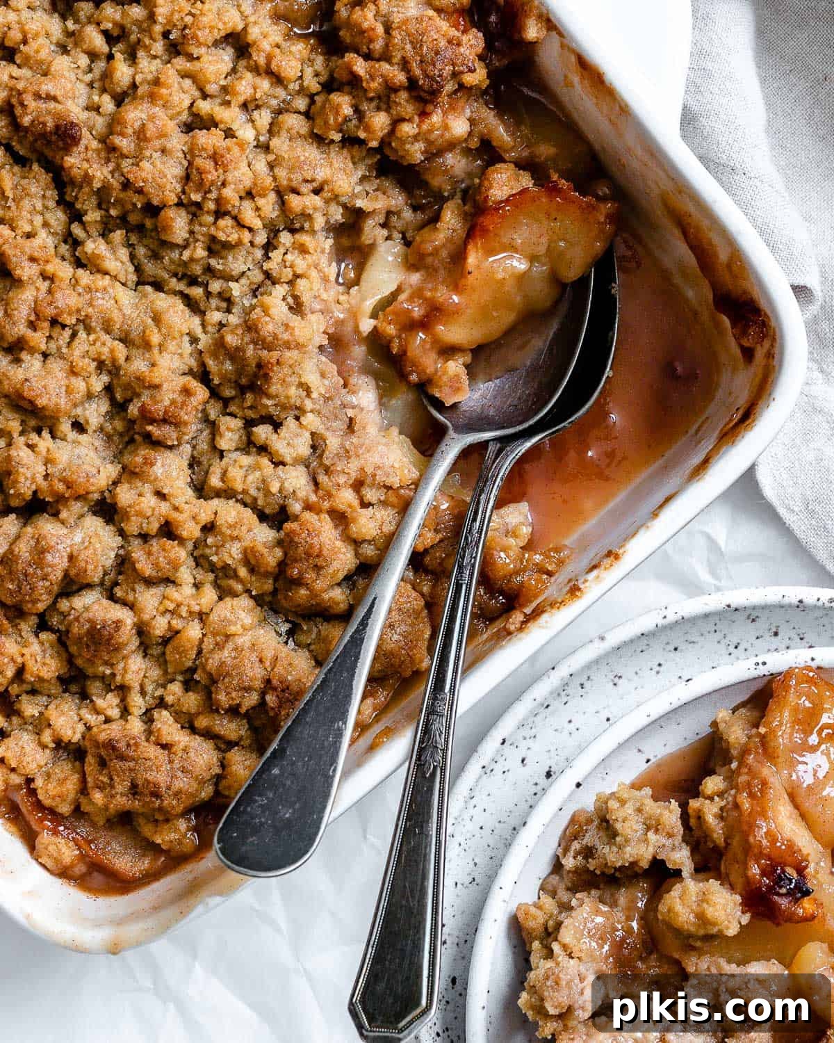 48 Irresistible Vegan Apple Delights 35 Completed Vegan Apple Crumble with a piece missing in a baking dish.