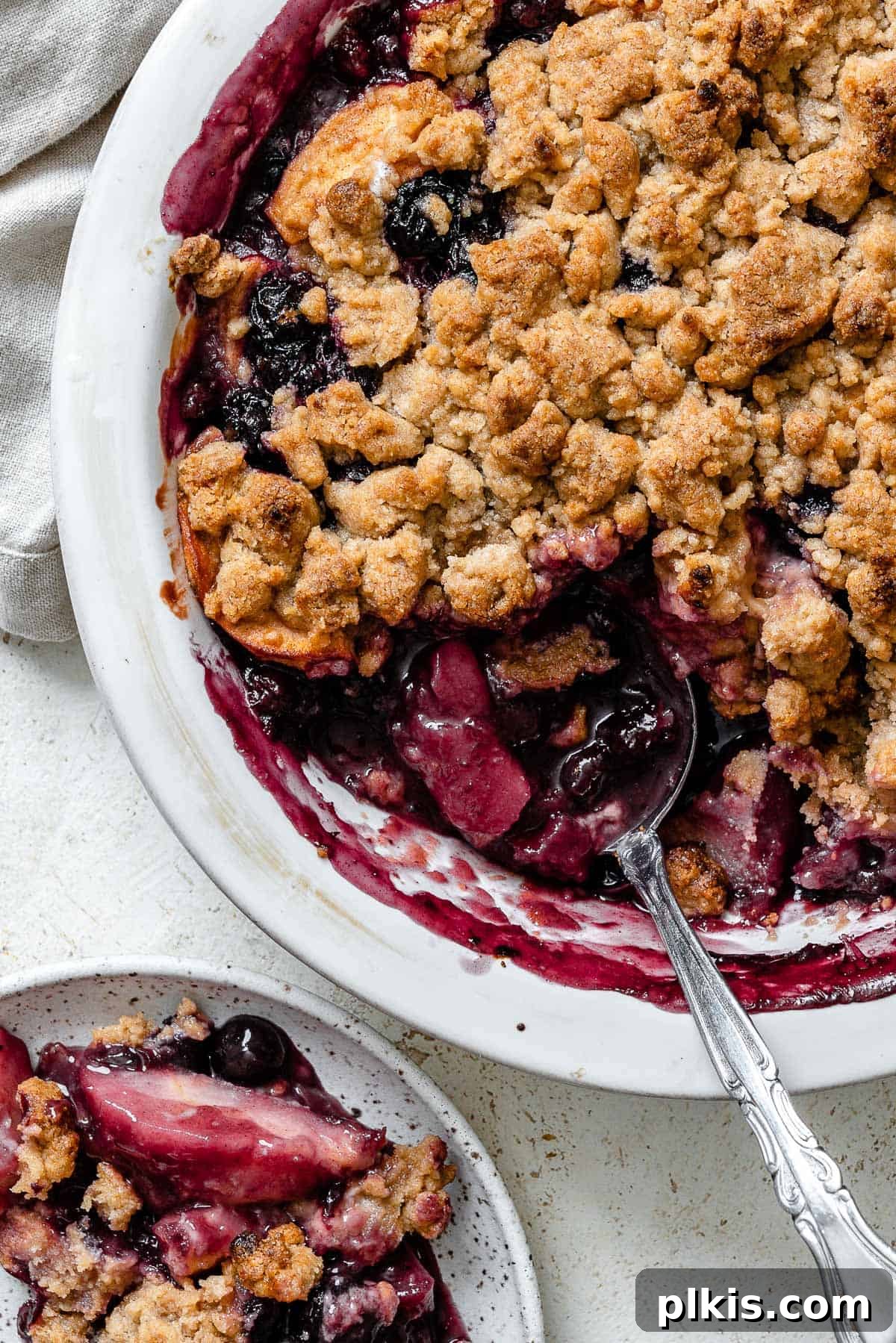 48 Irresistible Vegan Apple Delights 36 Completed Apple and Blueberry Crumble against a light background.