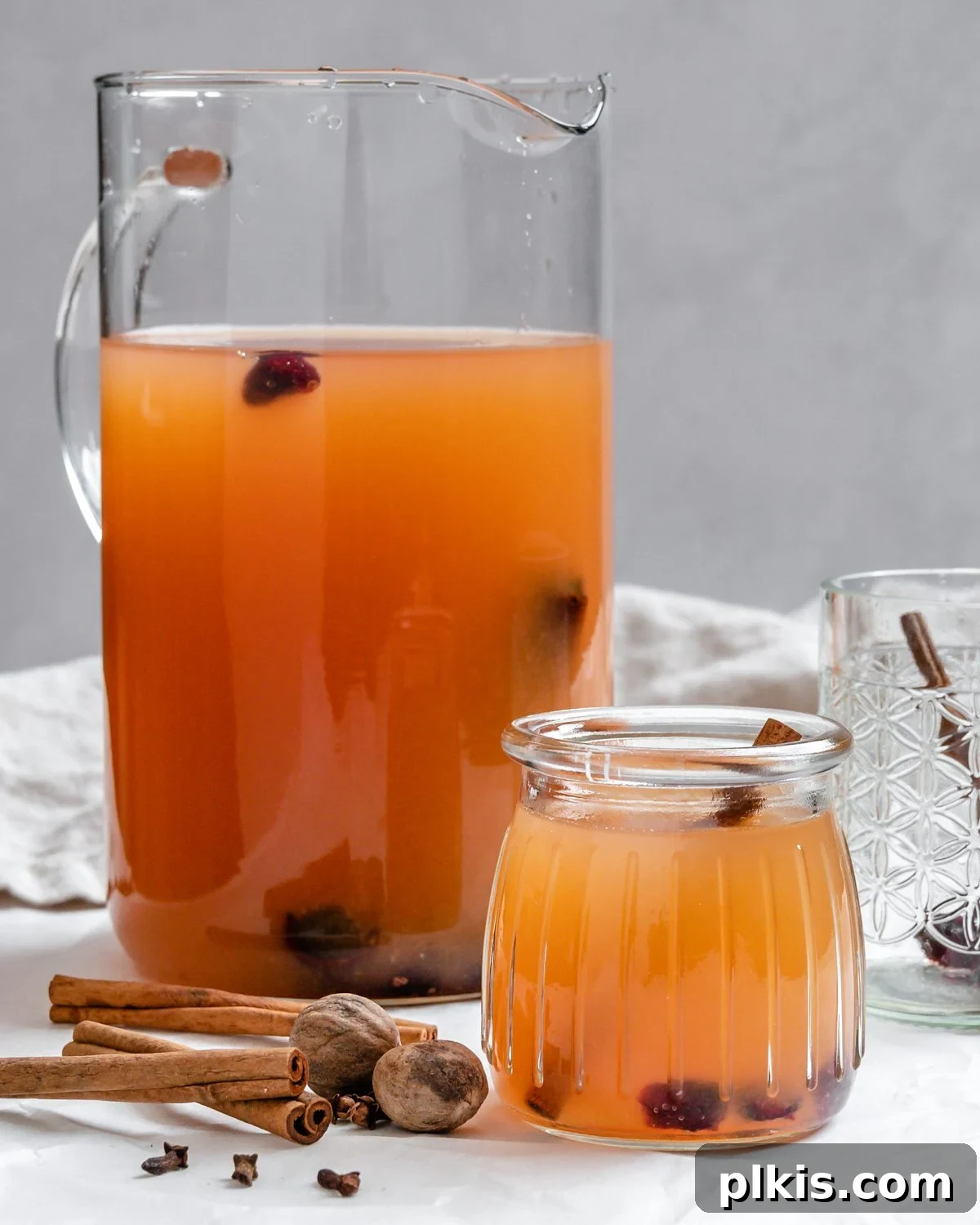 48 Irresistible Vegan Apple Delights 48 Completed Instant Pot Apple Cider in a cup and small glass.