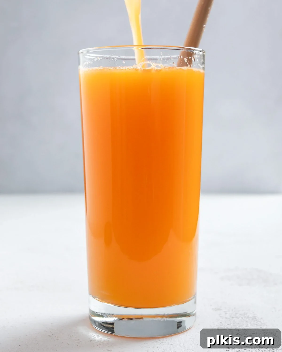 48 Irresistible Vegan Apple Delights 49 Completed Apple Orange Carrot Juice in a glass.