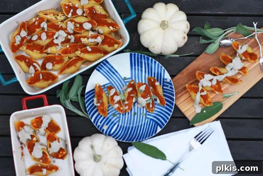 24 Effortless Plant-Based Pumpkin Creations from a Can 19 Beautifully arranged pumpkin stuffed shells on a blue plate and multiple platters, showcasing their rich filling and creamy sauce.