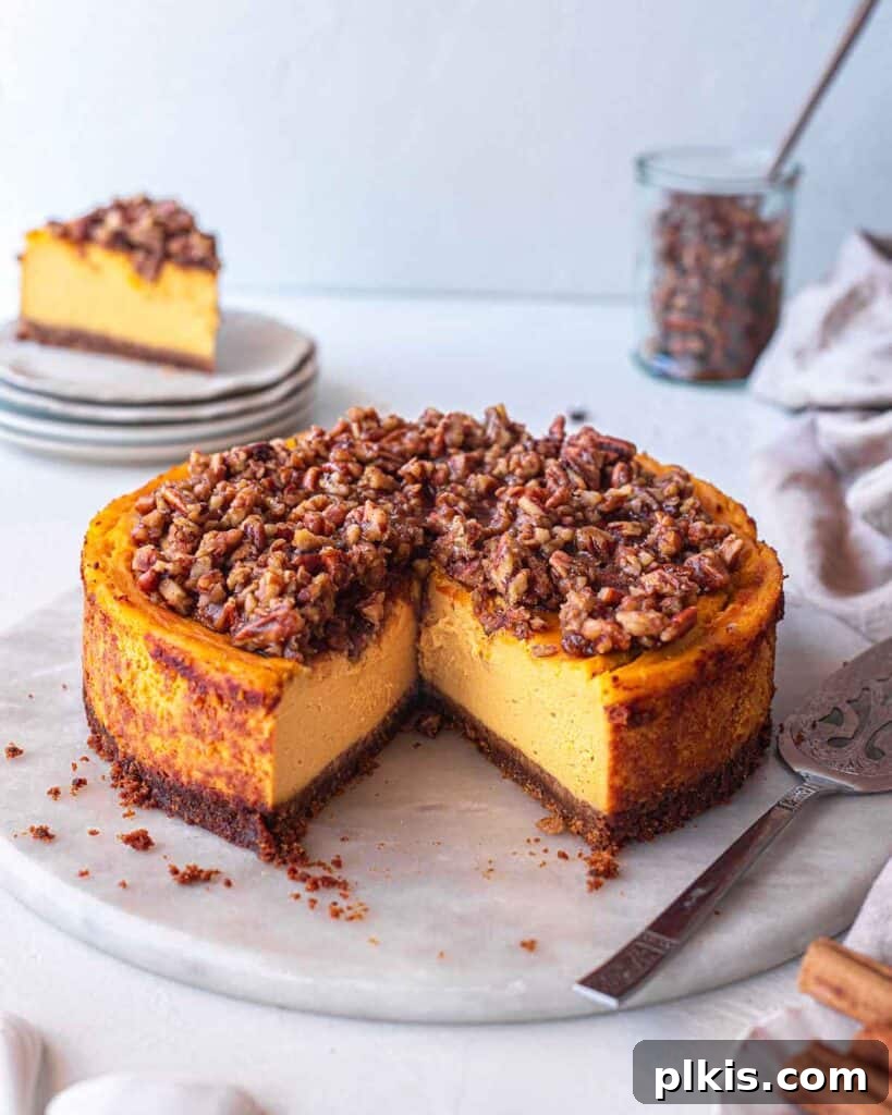 24 Effortless Plant-Based Pumpkin Creations from a Can 31 A beautifully baked vegan pumpkin cheesecake with a slice removed, revealing its creamy layers, with the rest of the cake in the background.