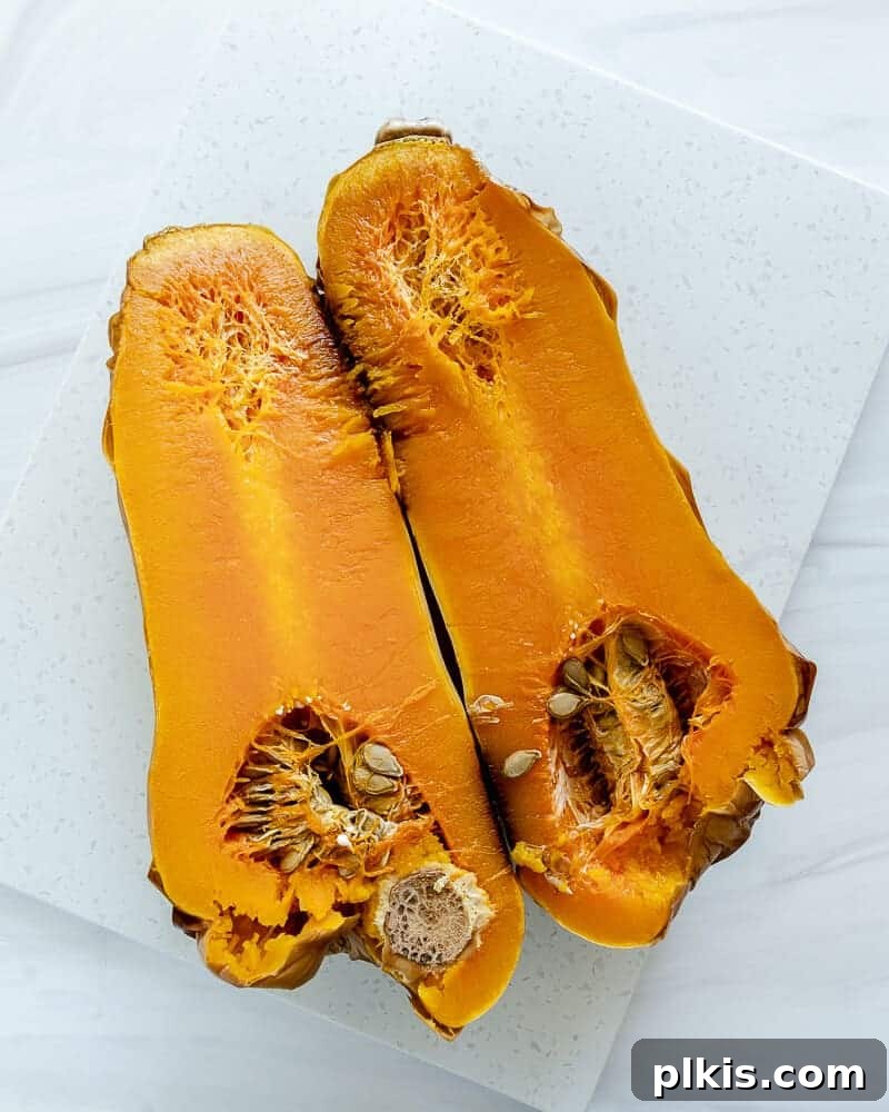 Perfectly roasted butternut squash cubes on a white background, highlighting their golden-brown edges and soft texture.