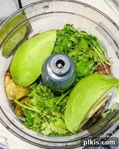 Velvety Tomatillo Avocado Verde 6 Close up of showing addition of veggies into blender.