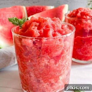 Completed Watermelon Slushie in two glasses with watermelon in the background.