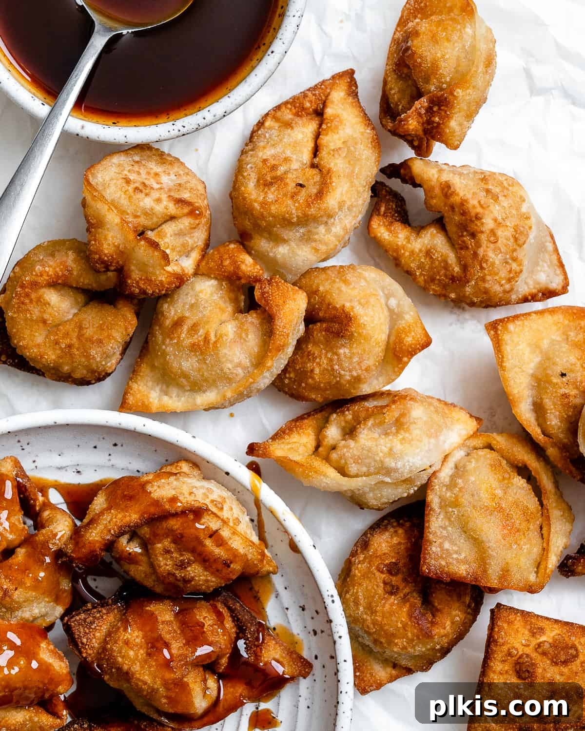 Golden Crispy Tofu Vegetable Wontons Made Two Ways 14 Several completed Tofu Vegetable Crispy Wontons spread out on a white surface, artfully arranged to showcase their inviting appearance.
